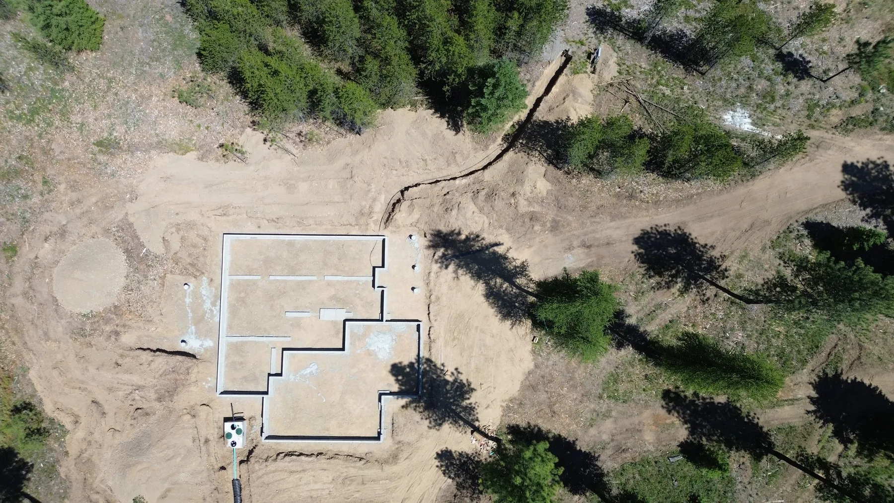 Overhead drone view of The Outlook's foundation on a freshly excavated five-acre corner lot.