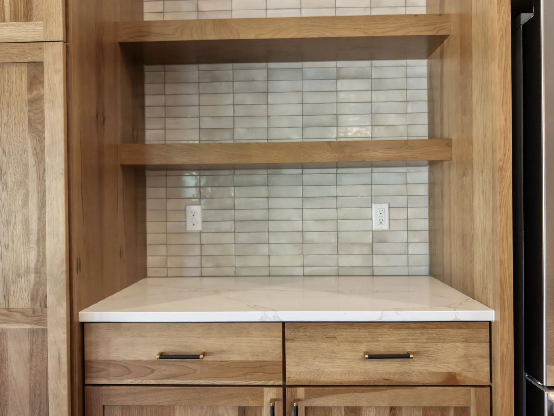 Built-in hickory cabinet with open floating shelves, a quartz counter and a glossy tile backsplash.
